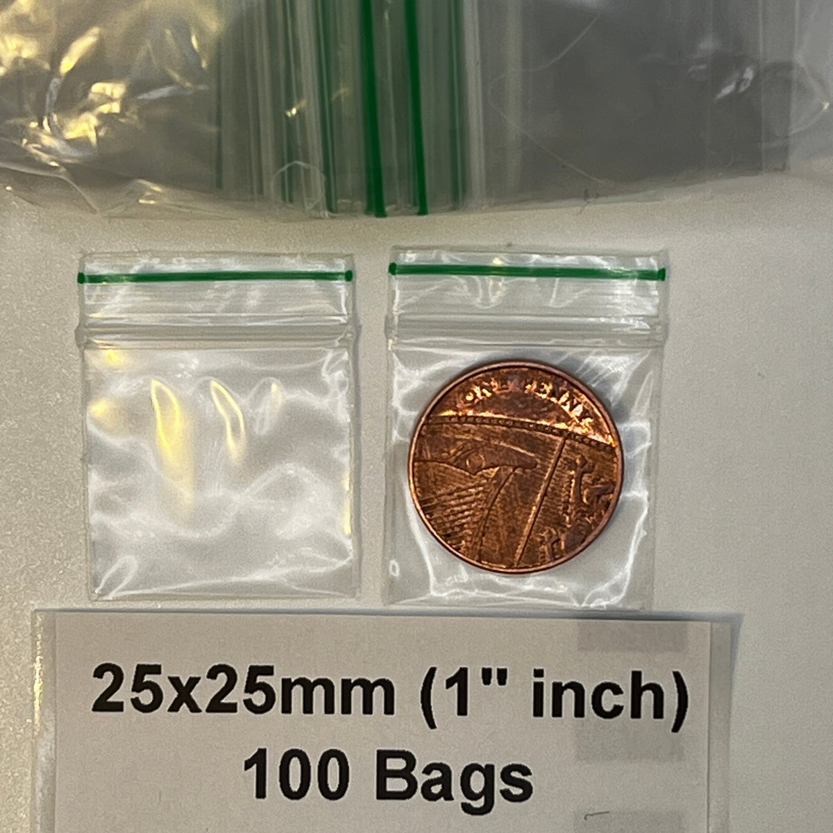 Two 25x25mm clear grip seal bags shown beside a UK penny