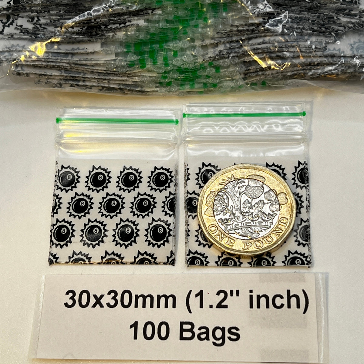 Two clear plastic zip-top bags with 8 ball print patterned , with £1 coin placed inside one bag for scale. A label at the bottom reads 30x30mm (1.2 inch)