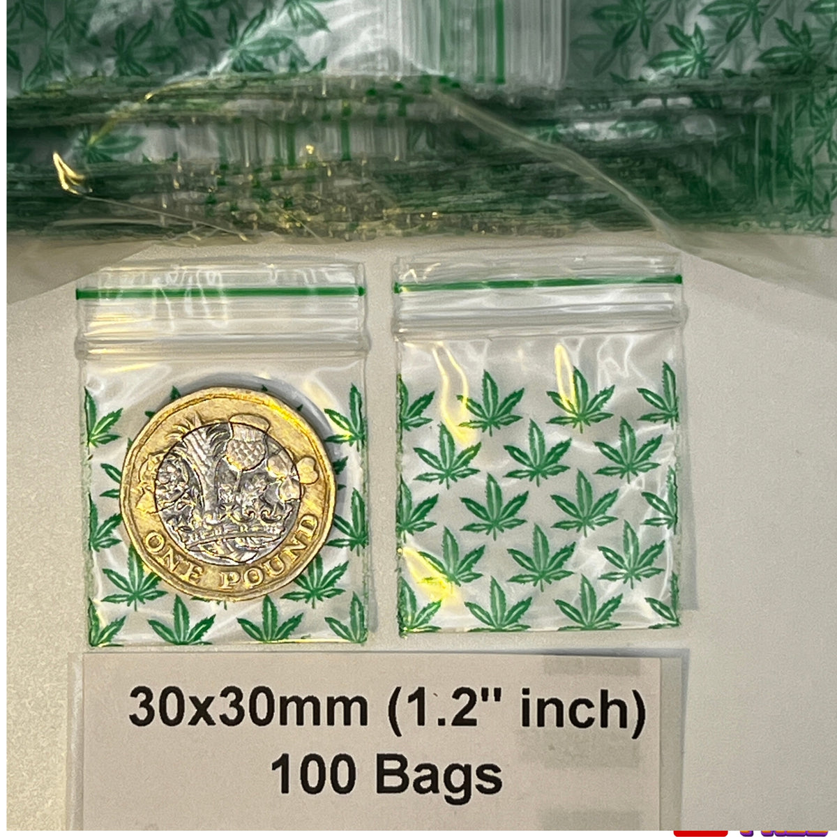 Two clear plastic zipper bags with green  leaf pattern print on a white background, one containing a £1 coin and the other empty. Text below reads 30x30mm 