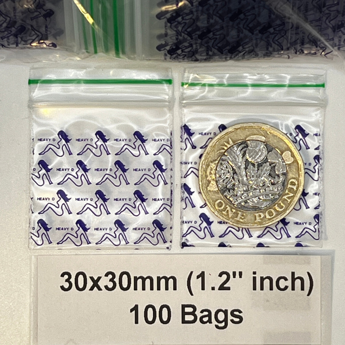 Two clear plastic zip-top bags with seating girl and text : heavy d printed on light background, one containing a coin and the other empty. A label at the bottom reads '30x30mm (1.2 inch)